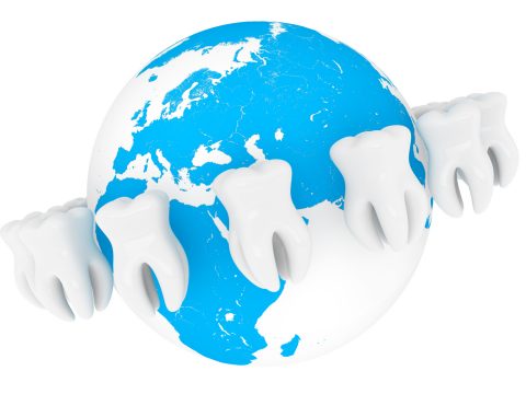 World Stomatology concept. Extreme closeup tooth with globe on a white background
