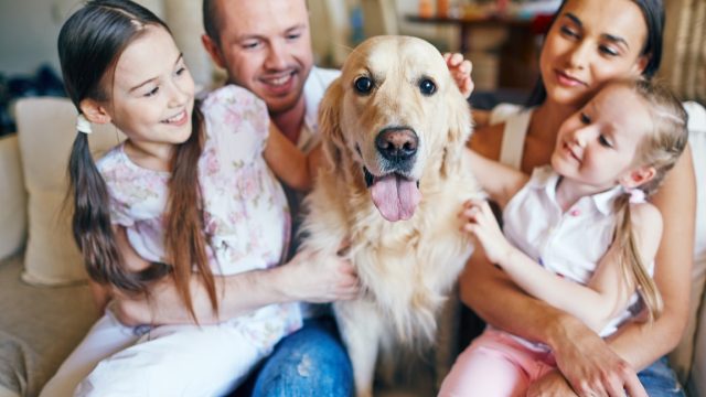 Happy family sitting together with their dog