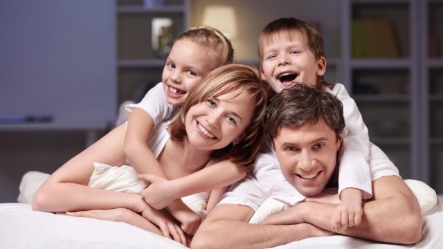 Families with children in bed at night at home